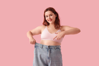 Picture of someone who has lost weight demonstrating by showing their old pants.