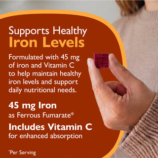 Promotional graphic for an iron supplement showing a hand holding a small dark red square tablet. Large text on a rust-orange background says it supports healthy iron levels and contains 45 mg iron and Vitamin C.