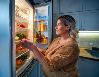 Picture of someone looking in their refrigerator full of healthy foods.